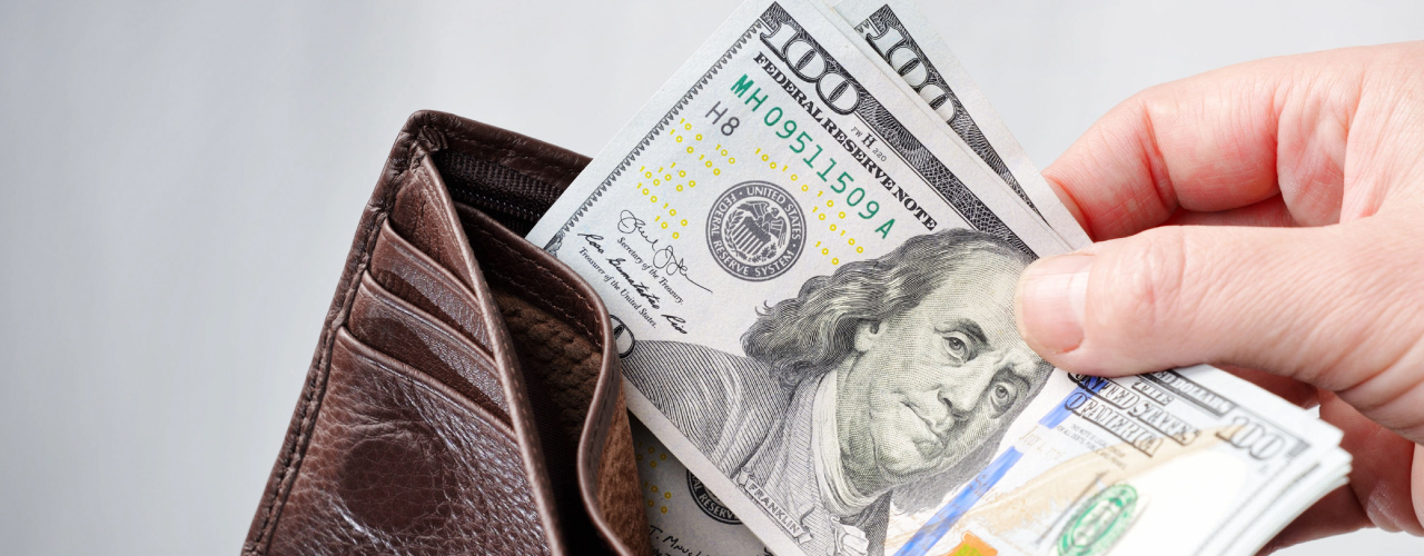 One wallet opened with two hundred dollar bills being pulled out.