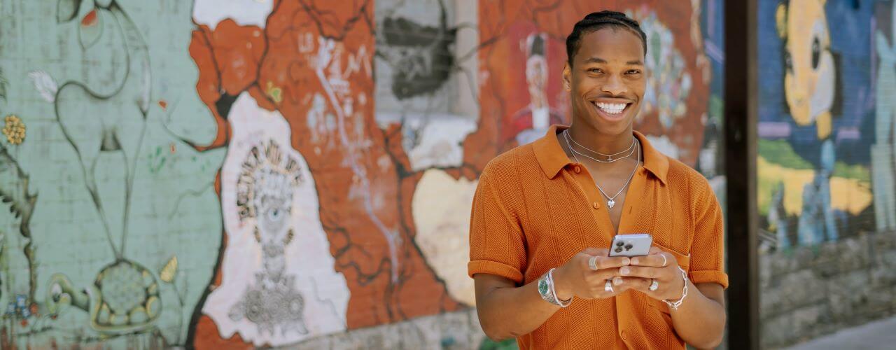 Man smiling while holding his phone.
