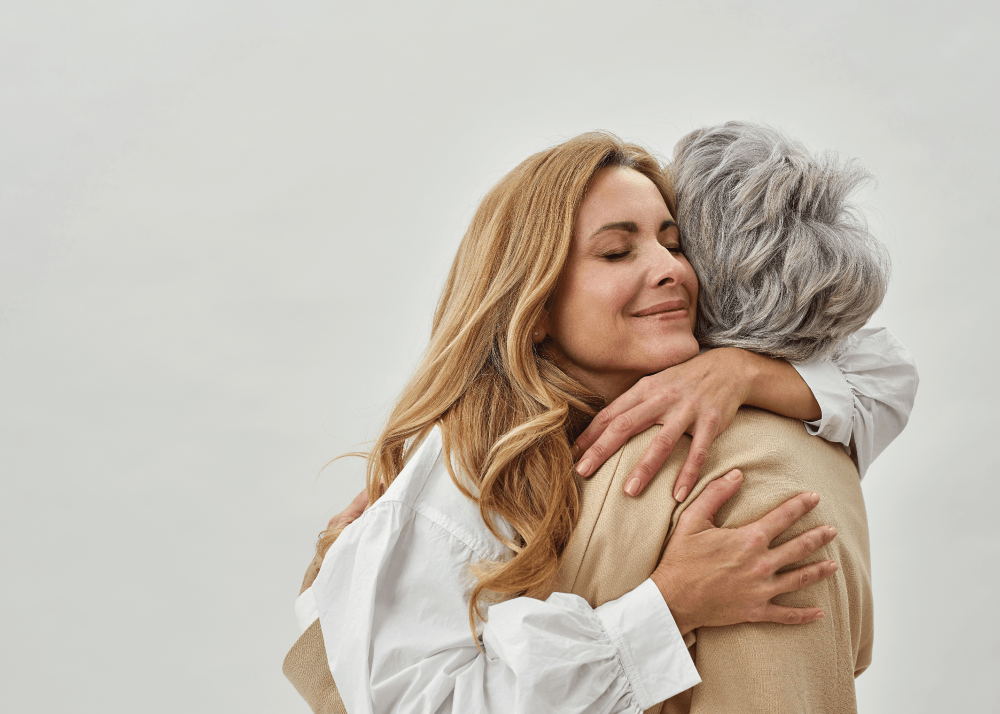 A mother and daughter hugging each other.